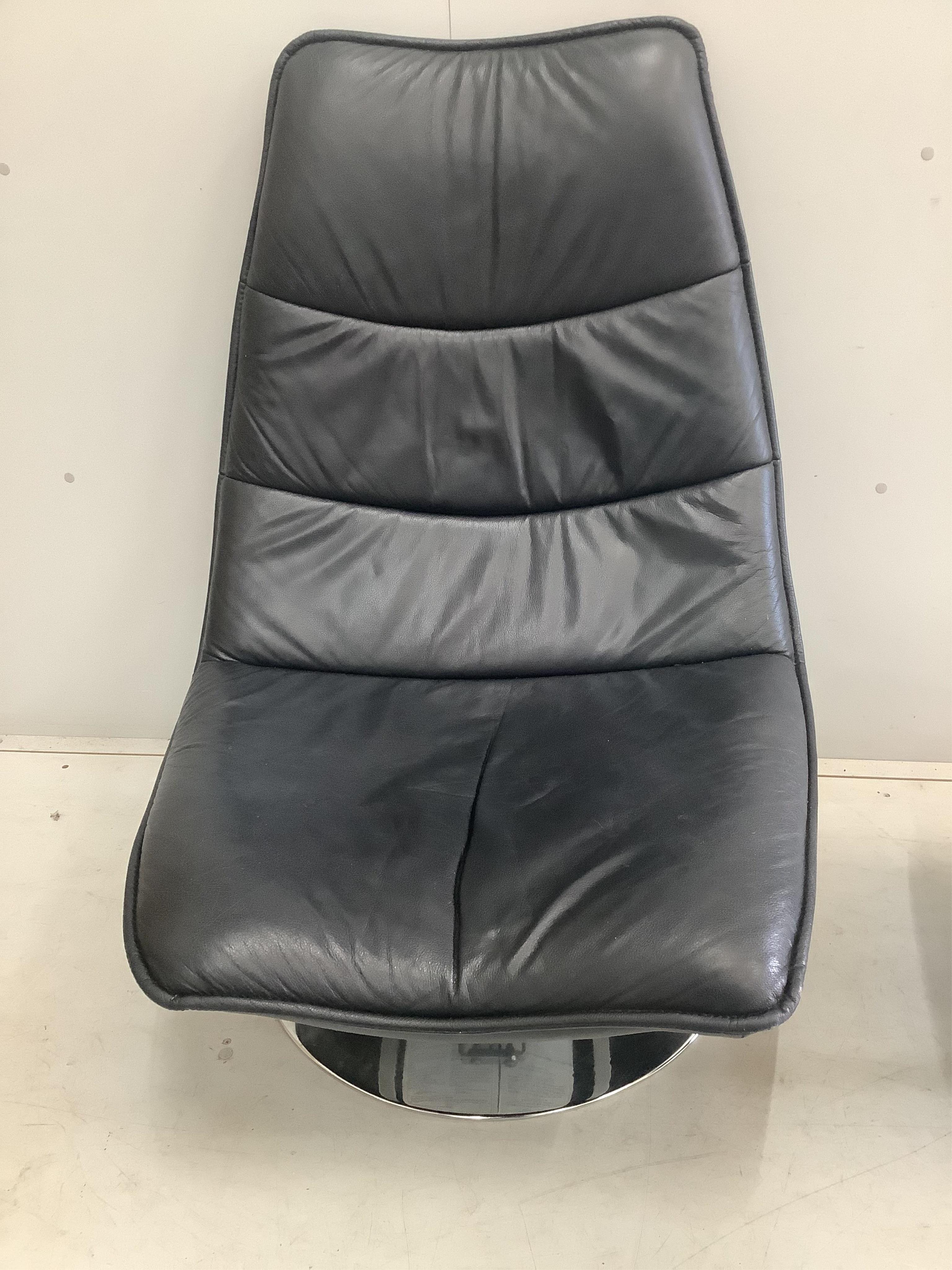 An Italian leather and chrome tilt and swivel chair, width 78cm, depth 74cm, height 104cm and a footstool